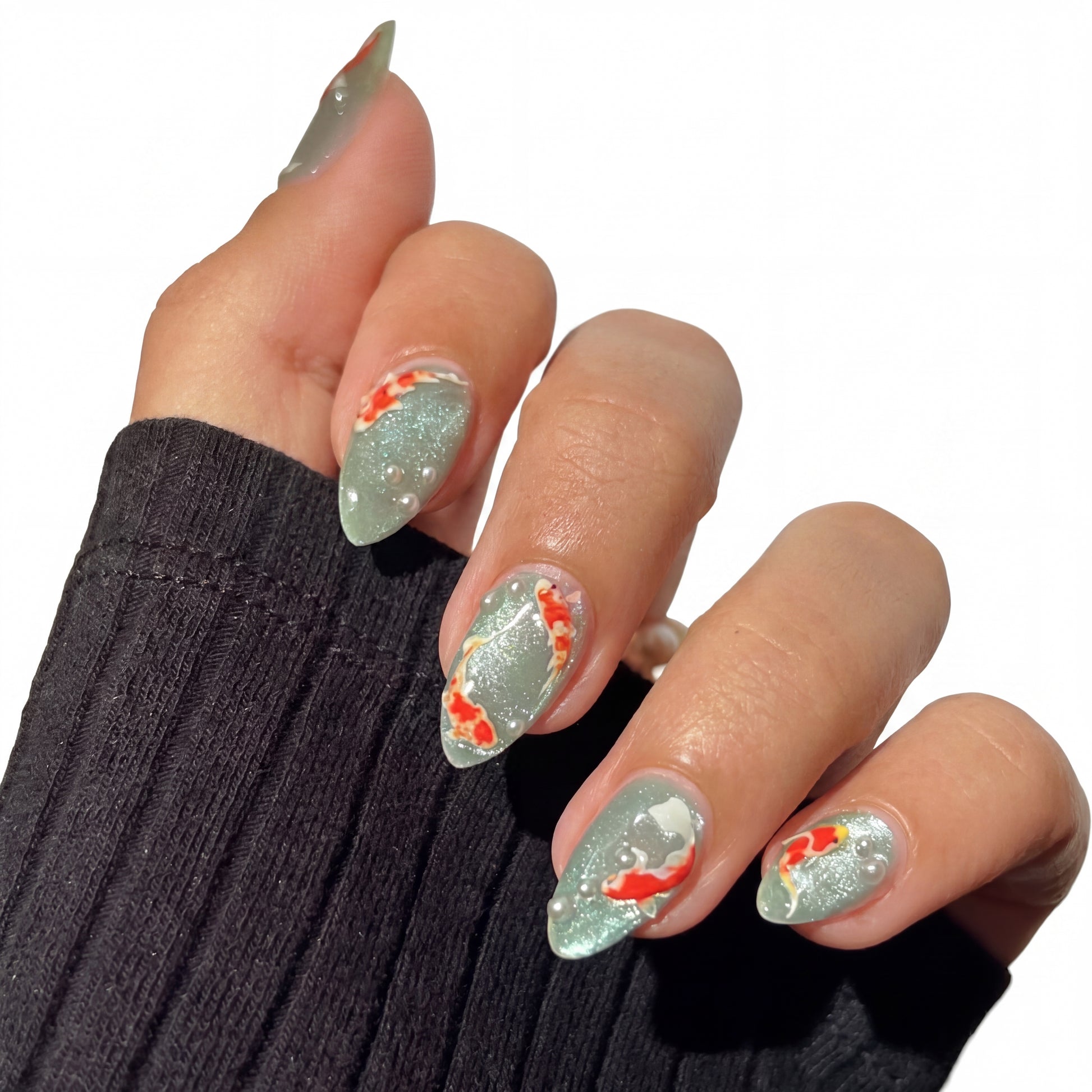 Sage Koi press-on nails on hand
